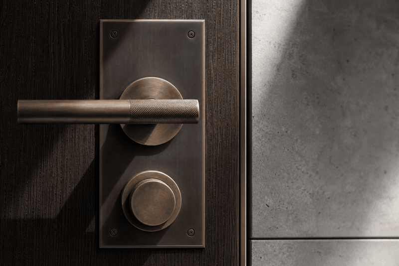Precision bronze hardware and blackened steel coordinated with dark oak and stone