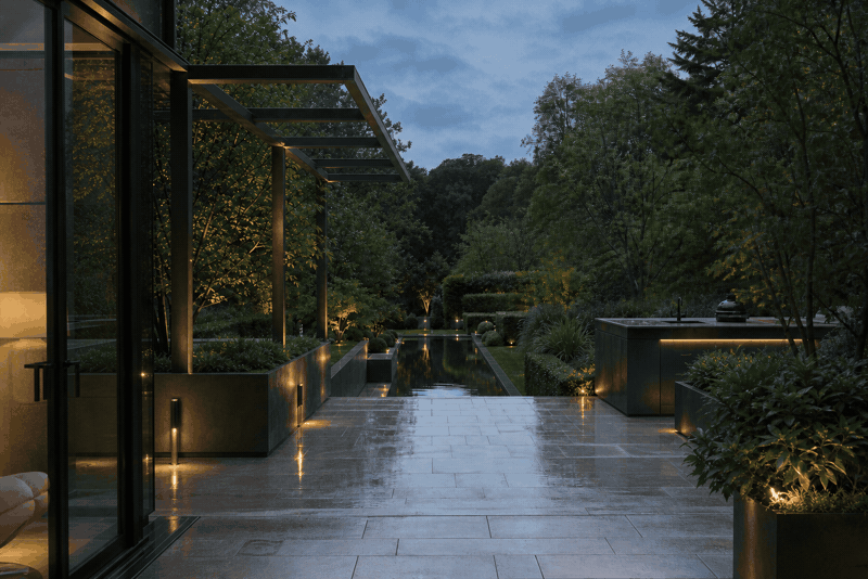 Contemporary garden with bespoke metal structures and a reflection pool at dusk