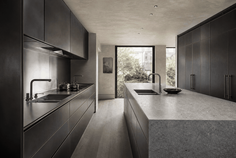 Bespoke blackened steel and stone kitchen overlooking a garden